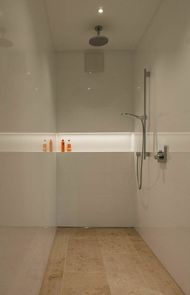 Entwurf im Waldhaus, Mönchengladbach-Hardt — Bodengleiche Dusche im Waldhaus mit Regenduschkopf, beleuchteter Wandnische und Natursteinboden — Innenarchitektur von Bernd Schüller