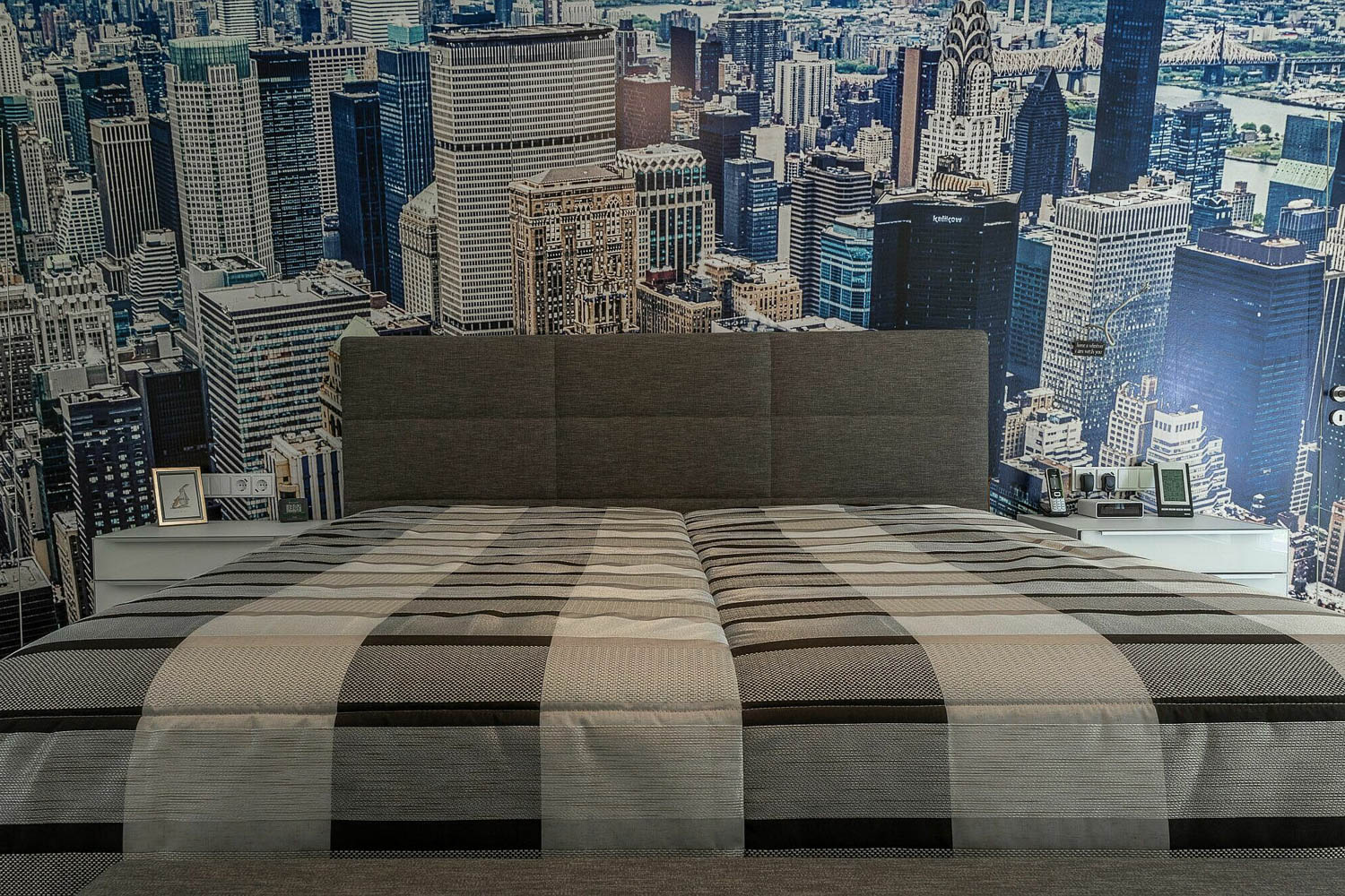 Entwurf im Waldhaus, Mönchengladbach-Hardt — Doppelbett im Waldhaus mit grauem Polsterkopfteil vor einer Skyline-Tapete — Innenarchitektur von Bernd Schüller