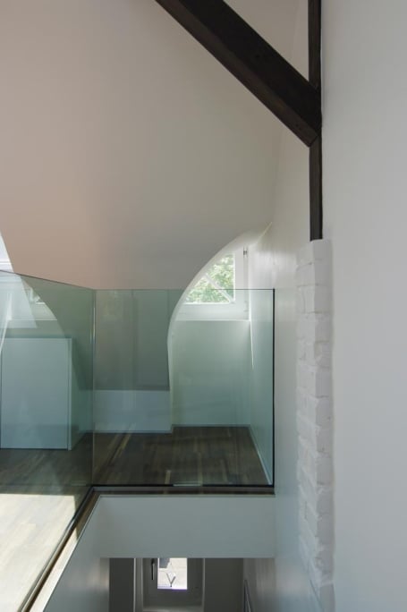 Umbau Dachgeschoss, Düsseldorf-Gerresheim — Glasgeländer am Treppenauge, dahinter ein Fenster in der weißen Dachschräge
