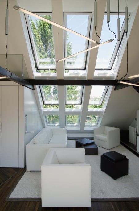 Umbau Dachgeschoss, Düsseldorf-Gerresheim — Wohnbereich unter zwei Reihen Dachfenstern mit weißen Sesseln und dunklen Dachbalken — Innenarchitektur von Bernd Schüller