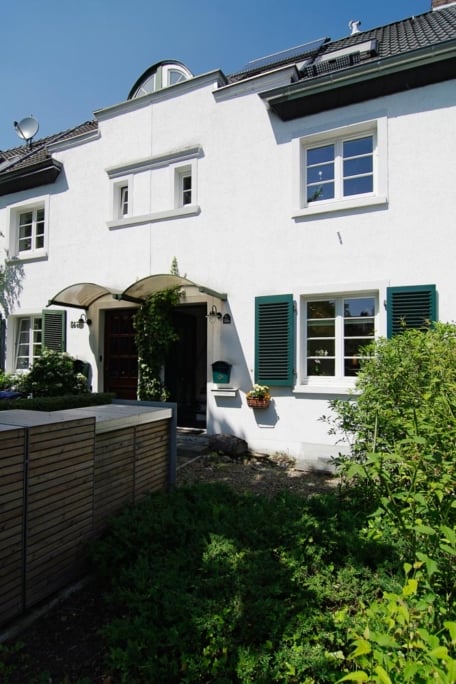 Umbau Einfamilienhaus, Düsseldorf-Gerresheim — Schmale Küchenzeile mit weißen Fronten und Einbaugeräten, Blick zum Esstisch am Ende
