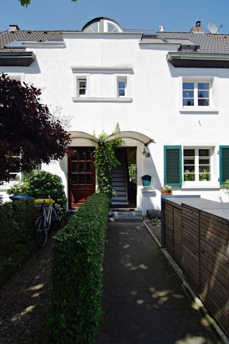 Umbau Einfamilienhaus, Düsseldorf-Gerresheim — Kaminecke mit gerahmtem Landschaftsbild über einem schwarzen Ledersessel mit Hocker