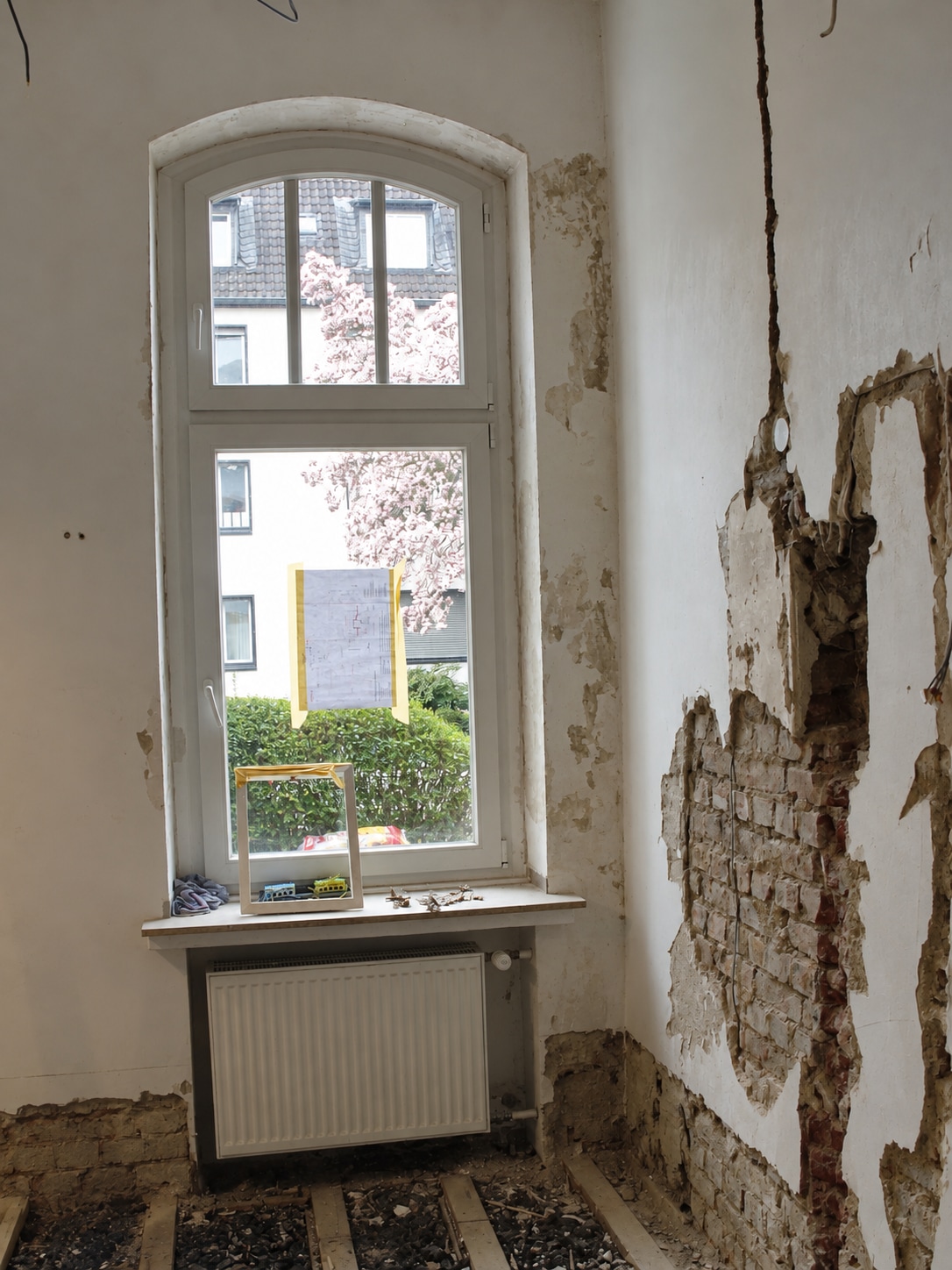 Masterbad im Rohbau mit Rundbogenfenster und freigelegtem Mauerwerk