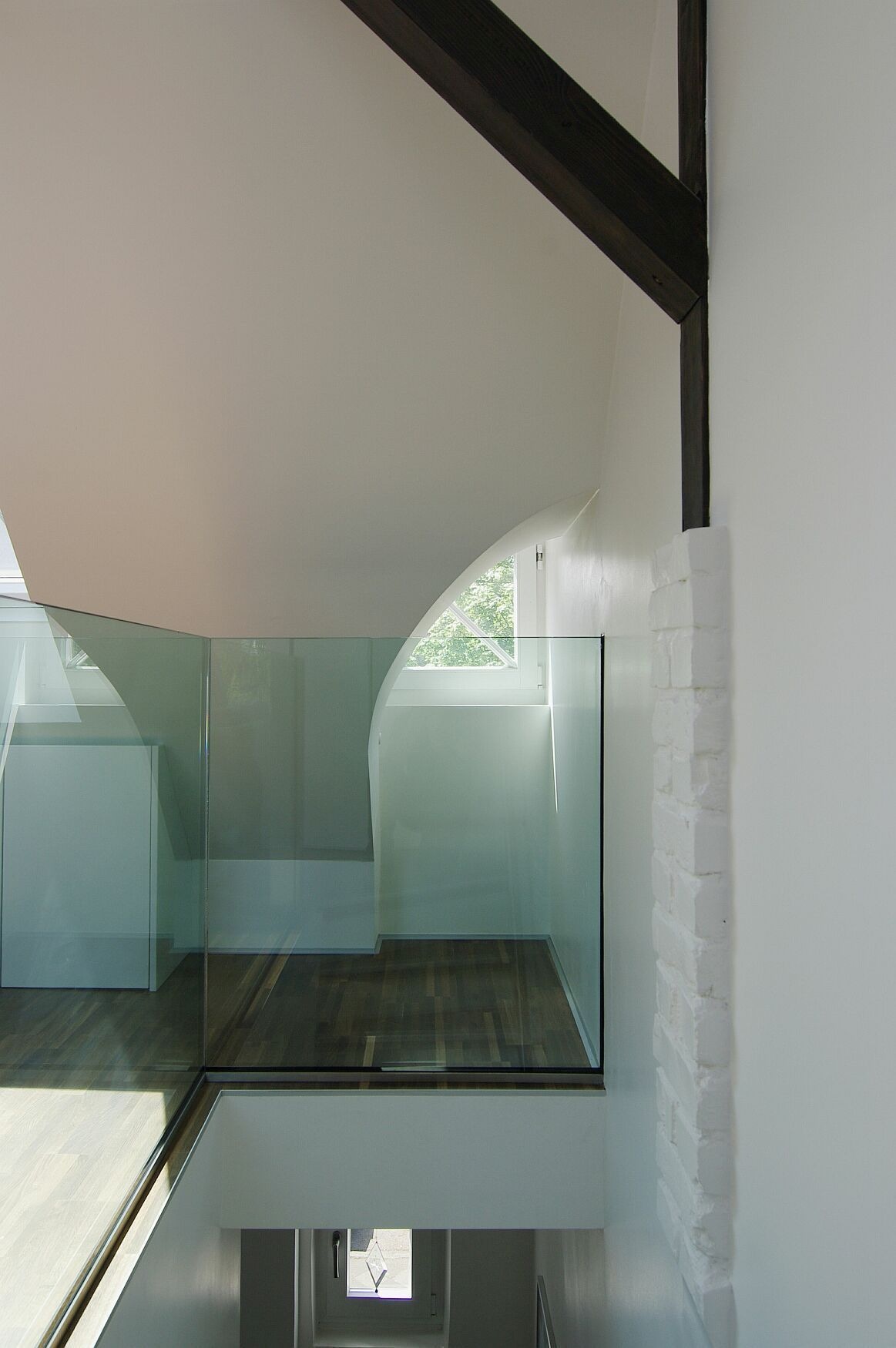 Galerieöffnung mit Glasbrüstung, weißer Dachschräge und Holzbalken in Düsseldorf-Gerresheim — Dachgeschossumbau von Bernd Schüller
