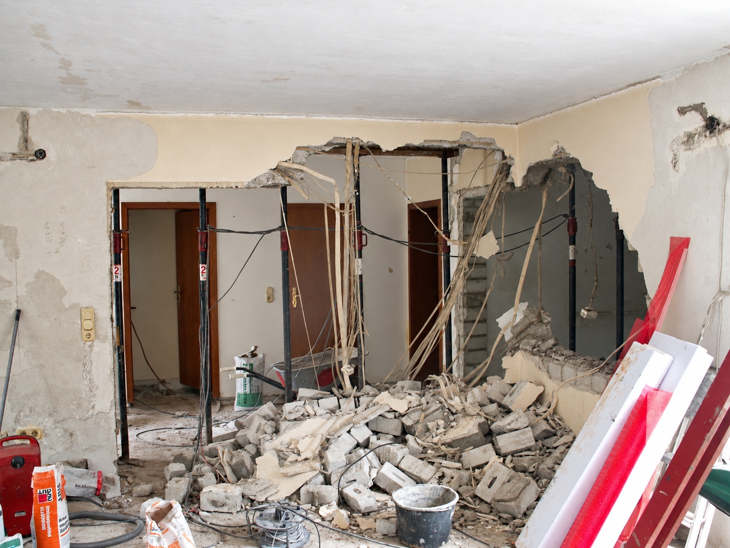 Abgebrochene Innenwände mit Baustützen, Leitungen und Bauschutt